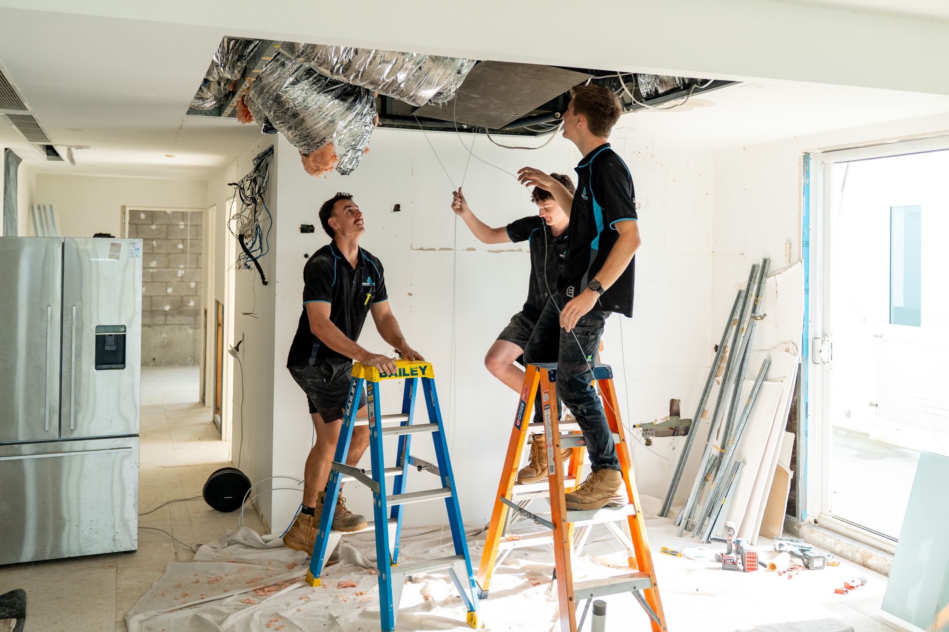 Delta Temp crew running ducting through an open ceiling at rough-in