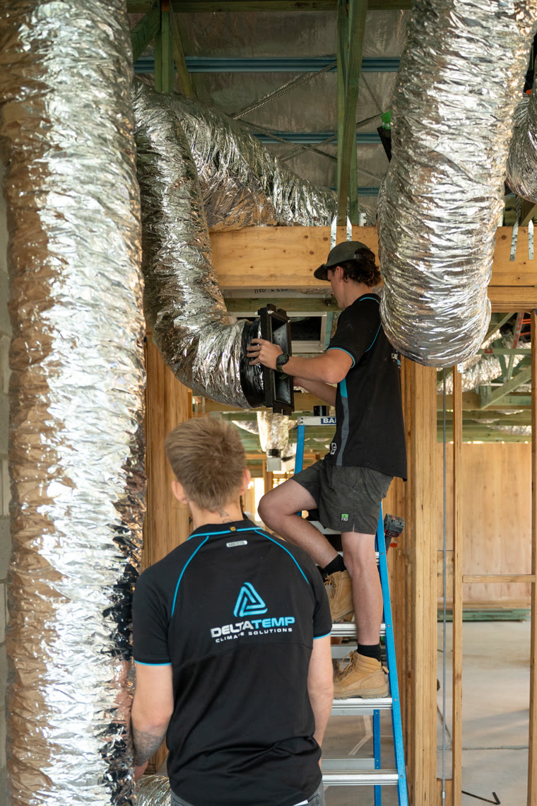 Delta Temp crew installing ducting into the ceiling space